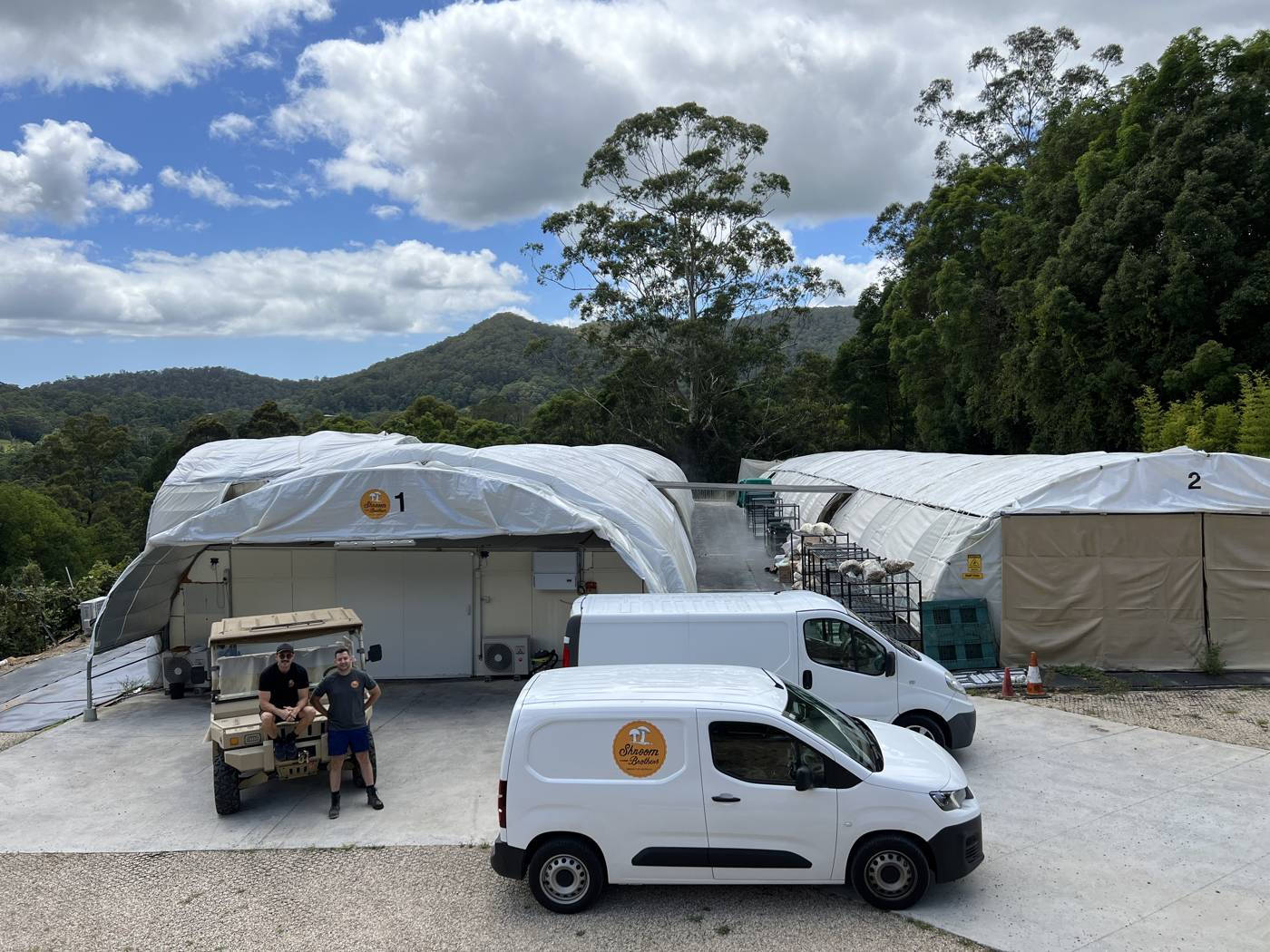 The Shroom Brothers farm: grow tents, delivery vans, and the brothers.